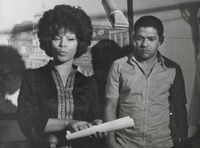 lossy-page1-1024px-Elza_Soares_recebendo_o_diploma_de_Embaixatriz_do_Samba_no_Museu_da_Imagem_e_do_Sim,_com_Garrincha_ao_fundo.tif.jpg